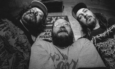 Bandmates from Billie's Burger Patrol pose in front of a brick wall.