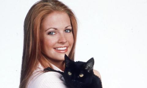 Sabrina the Teenage Witch smiles while holding Salem.