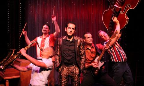 The Shakedown Shuffle pose with their musical instruments on stage.