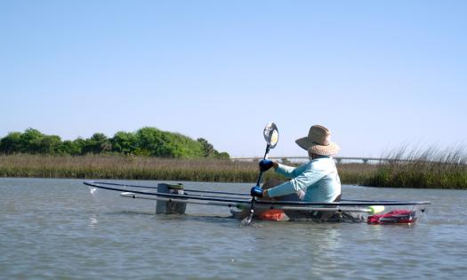 A kayaker in a transparent kayak with a view of Vilano Bridge