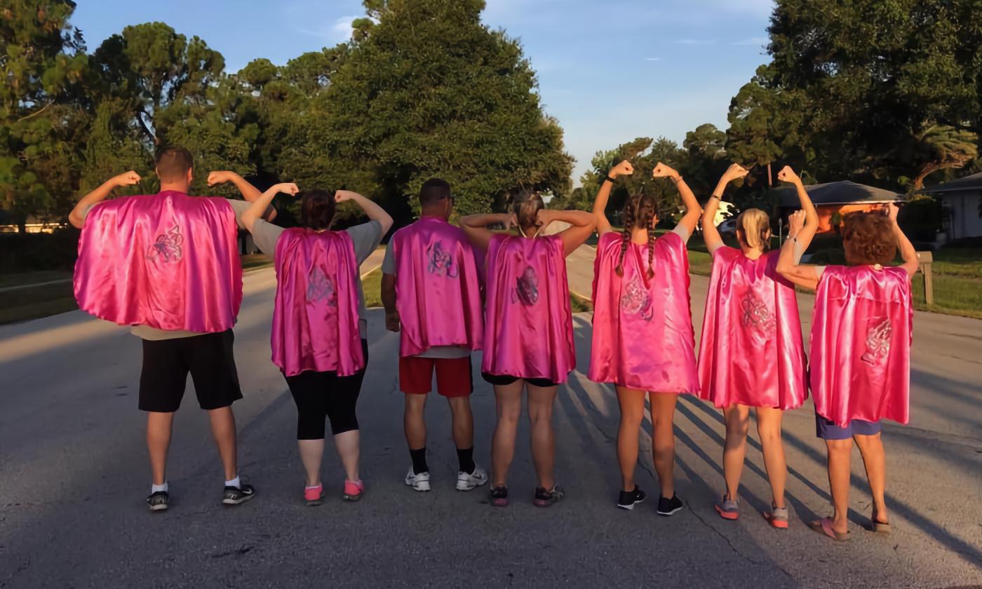 A group of runners showing their capes for the Capes and Tiaras 5K.