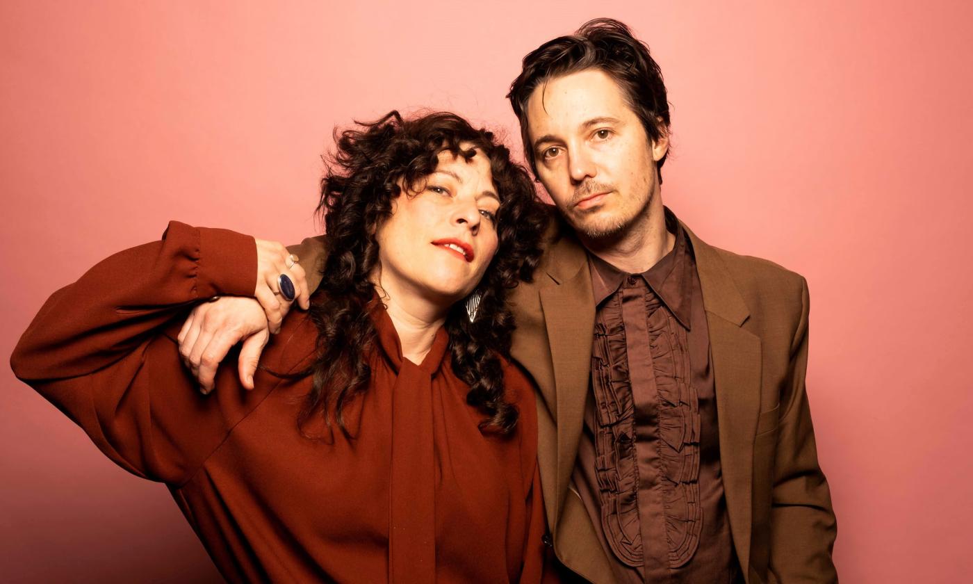 The wife and husband duo, Shovels and Rope, against a red background