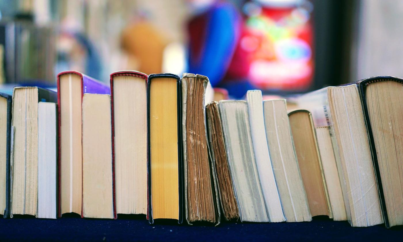 A stack of books are lined in a row.