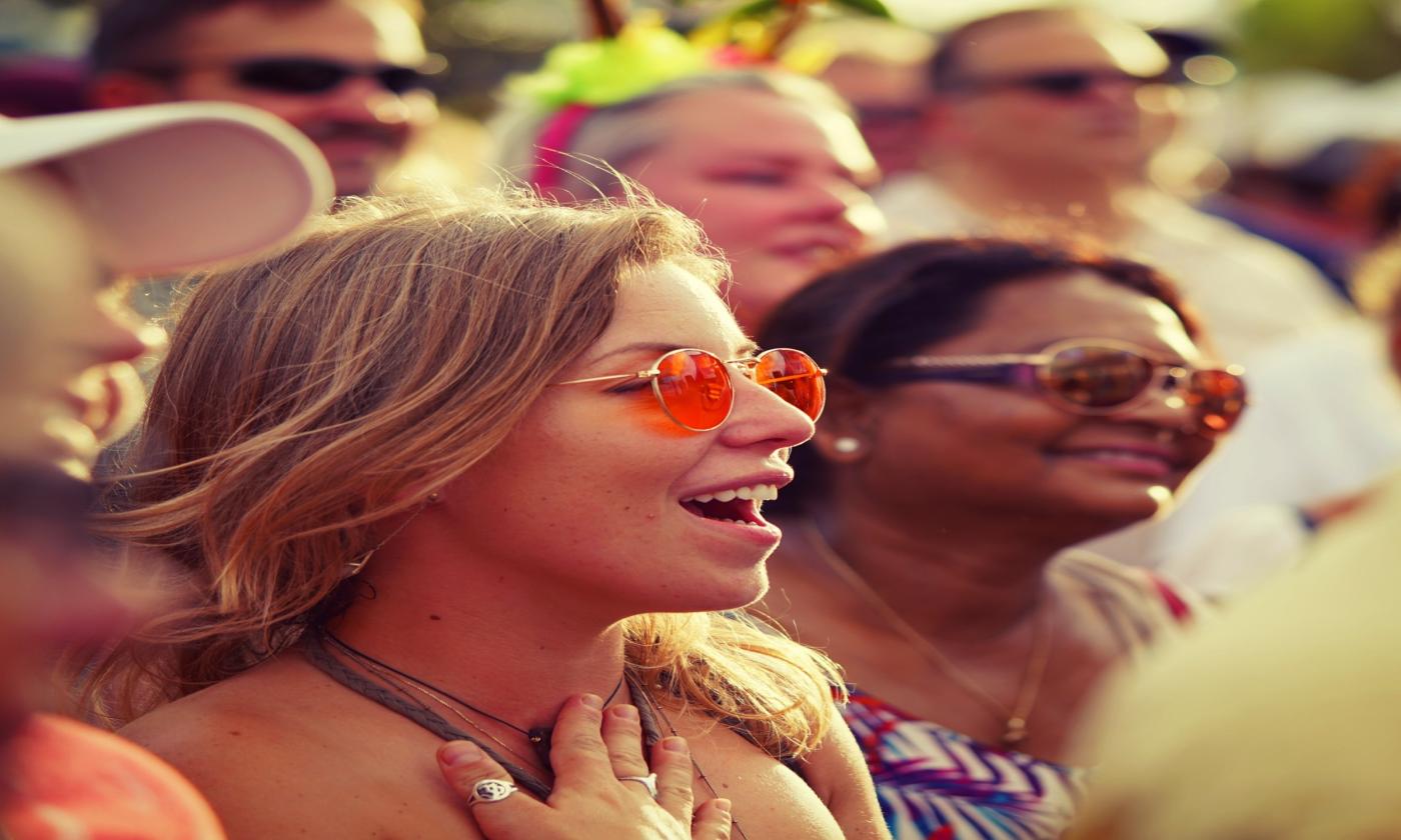 Woman smiles in a crowd.