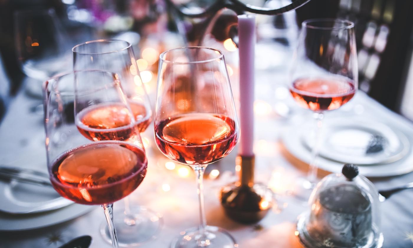 A glass of wine sits on the table.