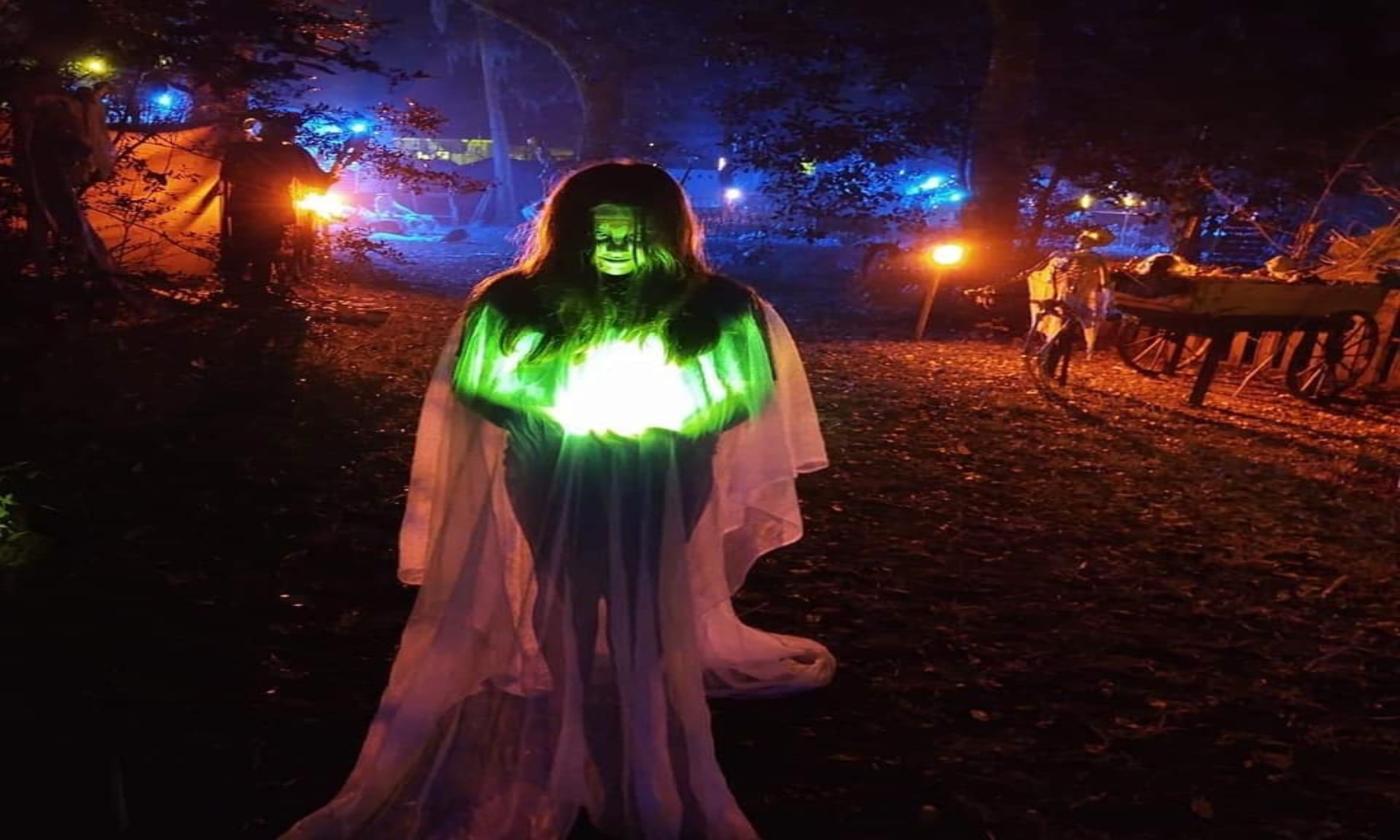 A woman dressed as a ghost stands in front of Shantytown.
