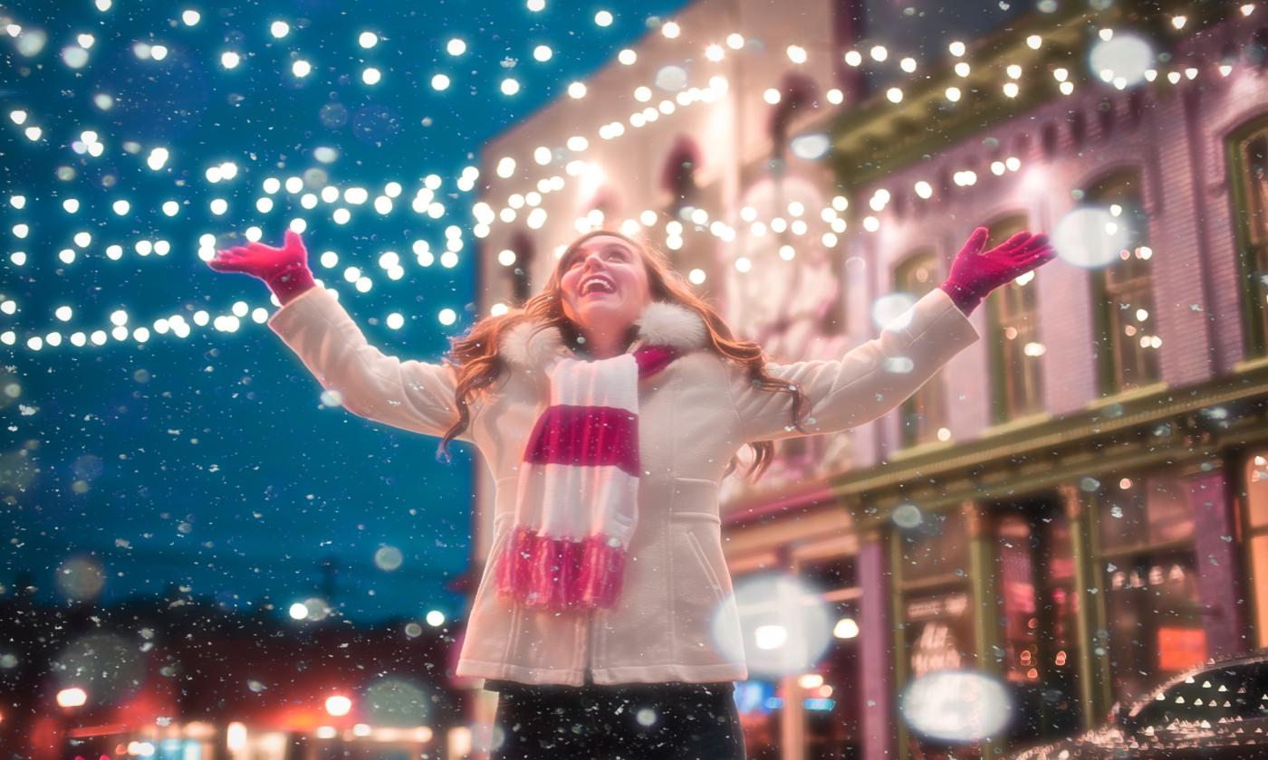 A woman smiles because it is snowing. 