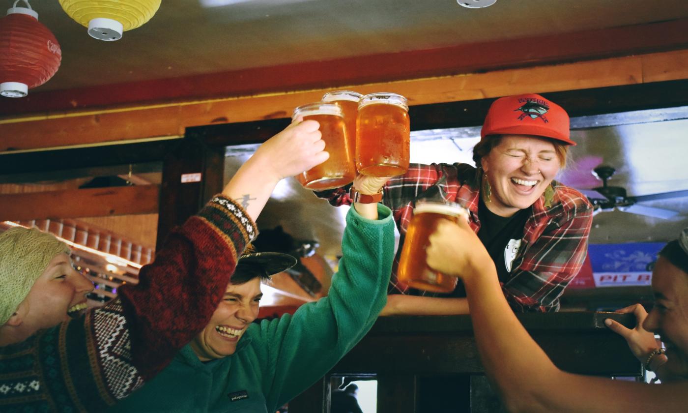 A group of people laugh at the bar.