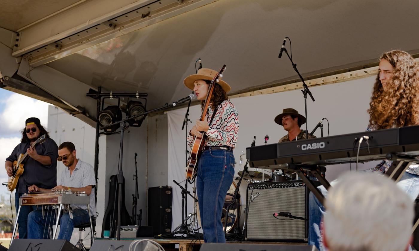 The band, Patsy's Day Dream performing on an outdoor stage, with a white background and cover