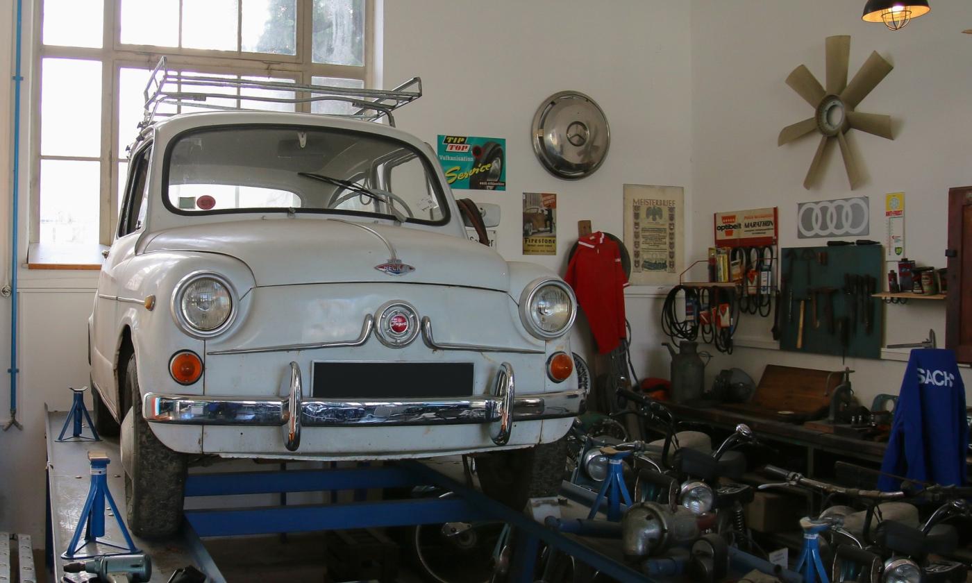 A white antique Neckar-Fagst on a lift in a garage