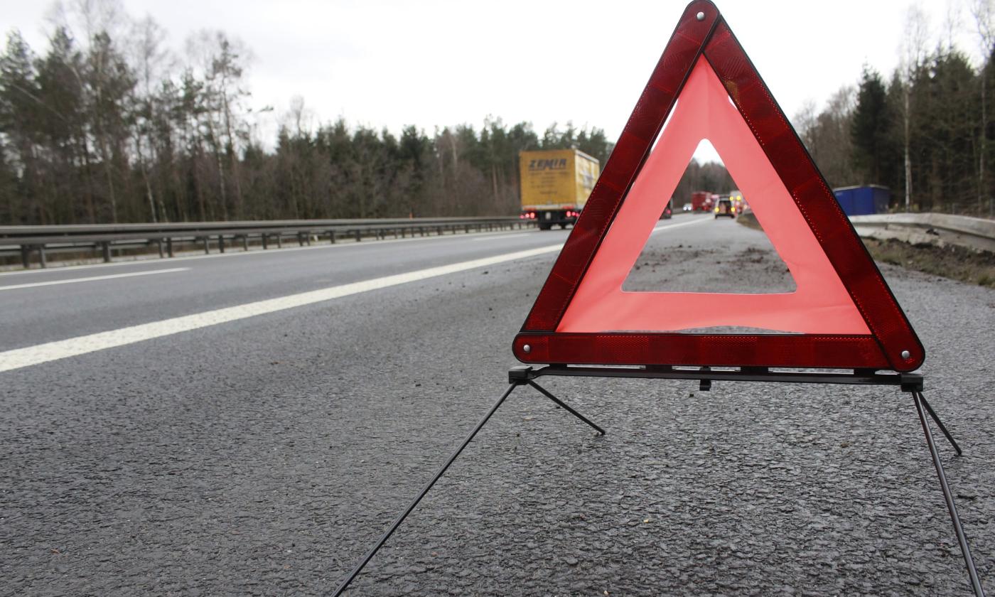 A warning triangle standing at the edge of a road to signal a slowdown ahead