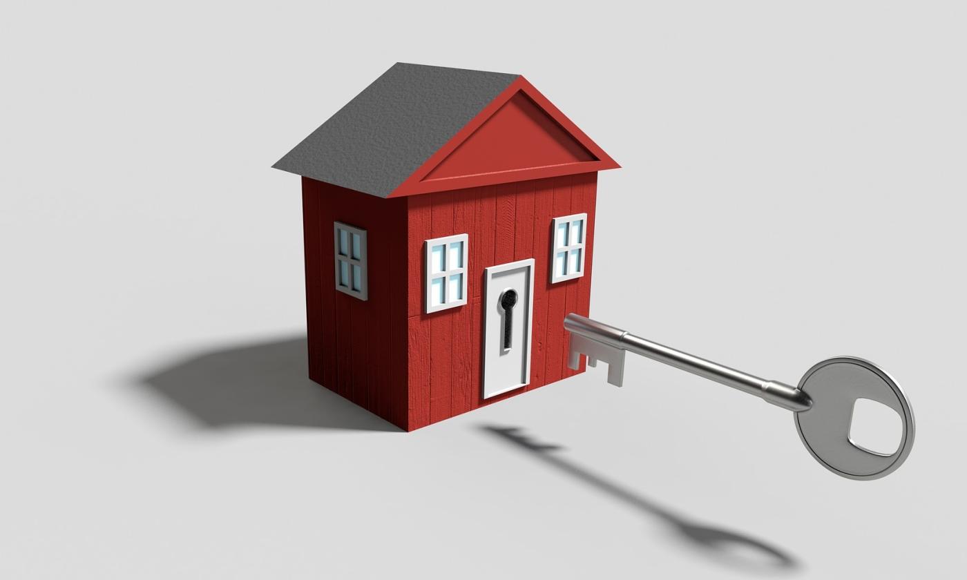 A red play house with a full size key aimed for the door