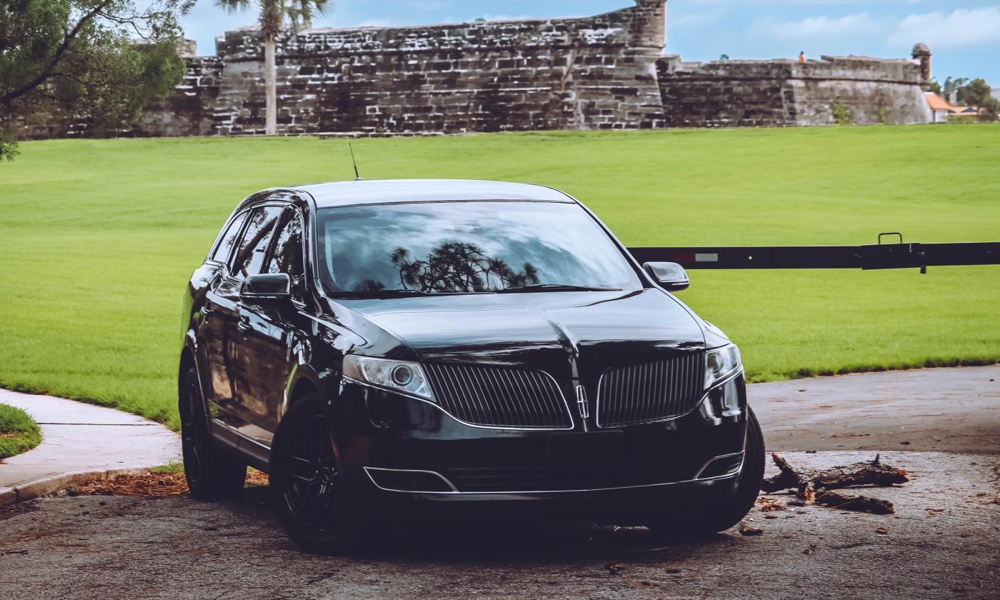 A luxury sedan is positioned in front of grass.