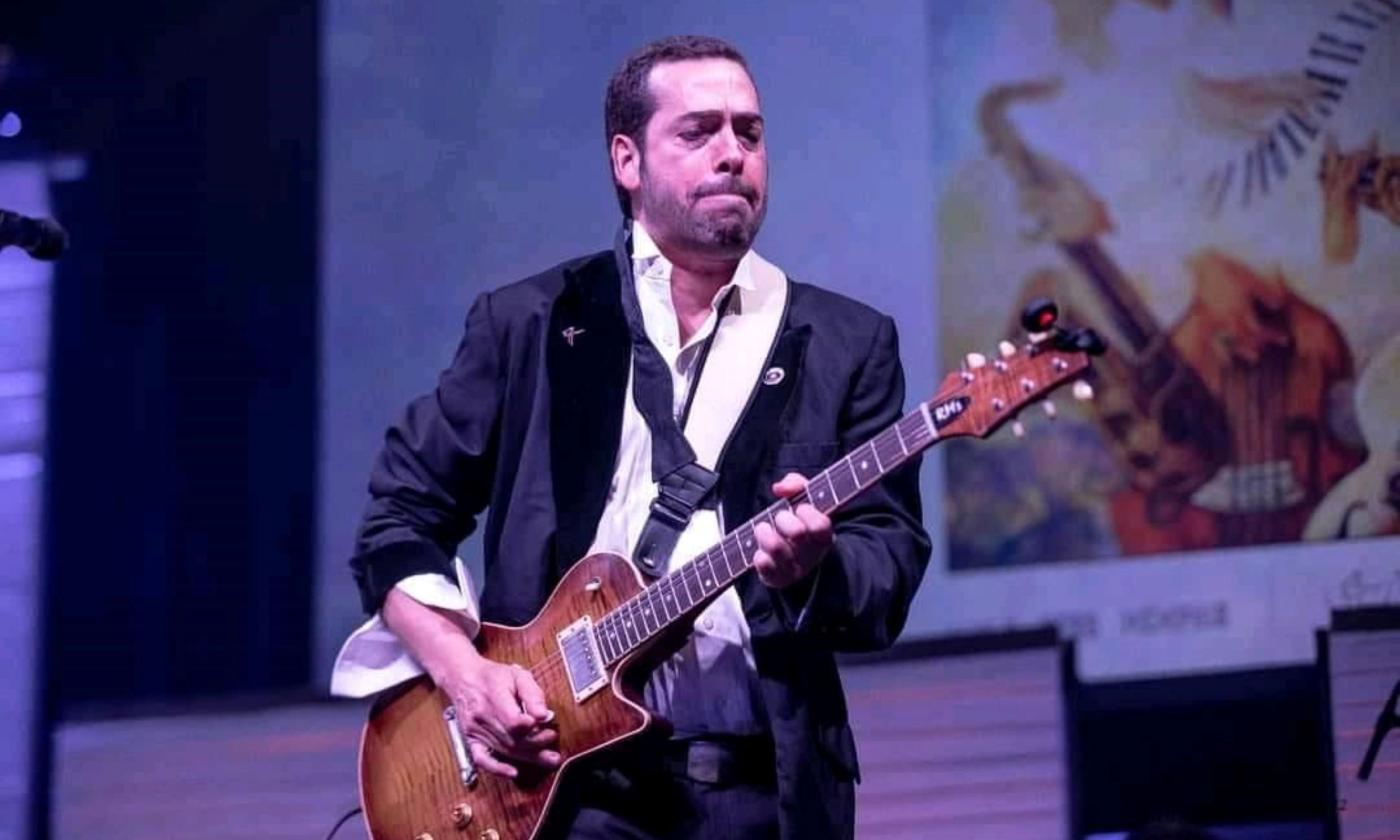 Albert Castiglia performs on stage with his guitar. 