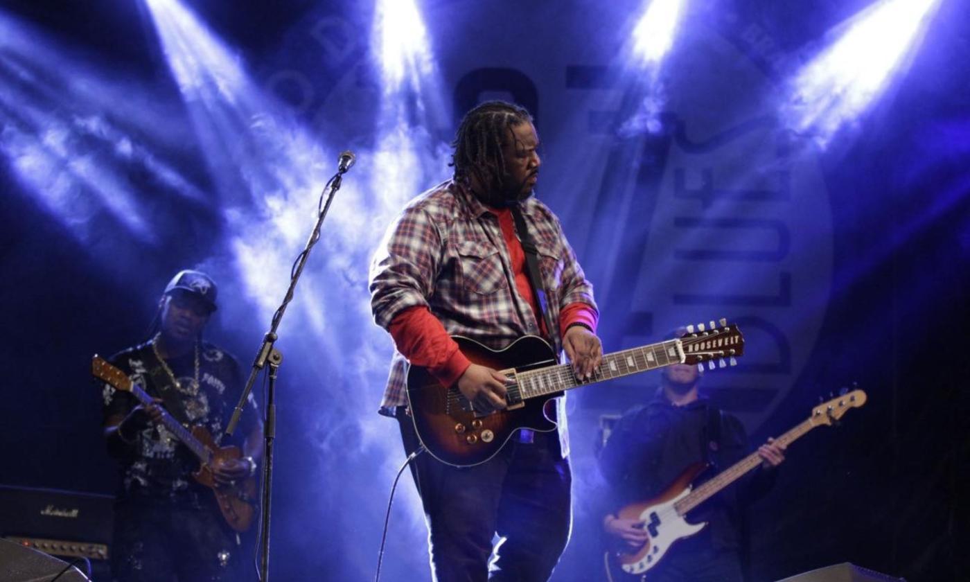 Roosevelt Collier plays his guitar on stage. 