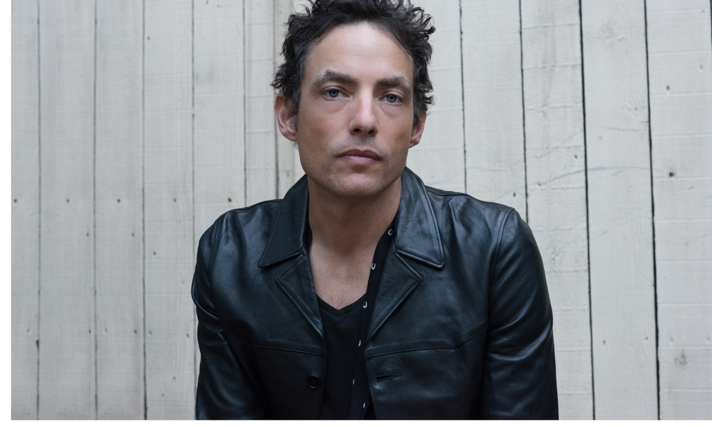 The Wallflowers stand in front of a white backdrop.