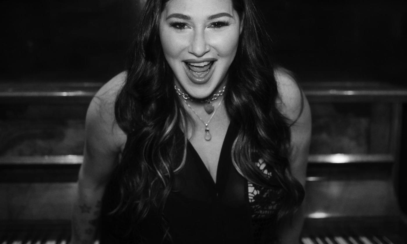 Tiffany smiles in front of a piano.