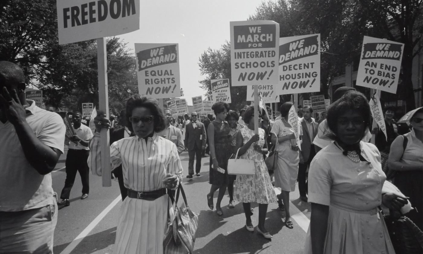 A group of women and men protest in the street.