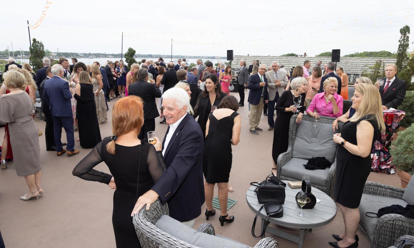 People enjoying cocktails on the deck of the White Room for Miracle on the Bayfront