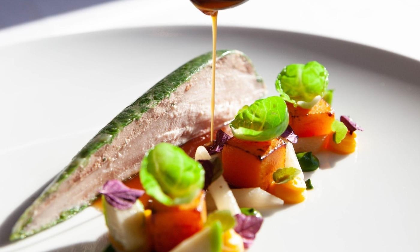 Sauce is drizzled over a culinary dish.
