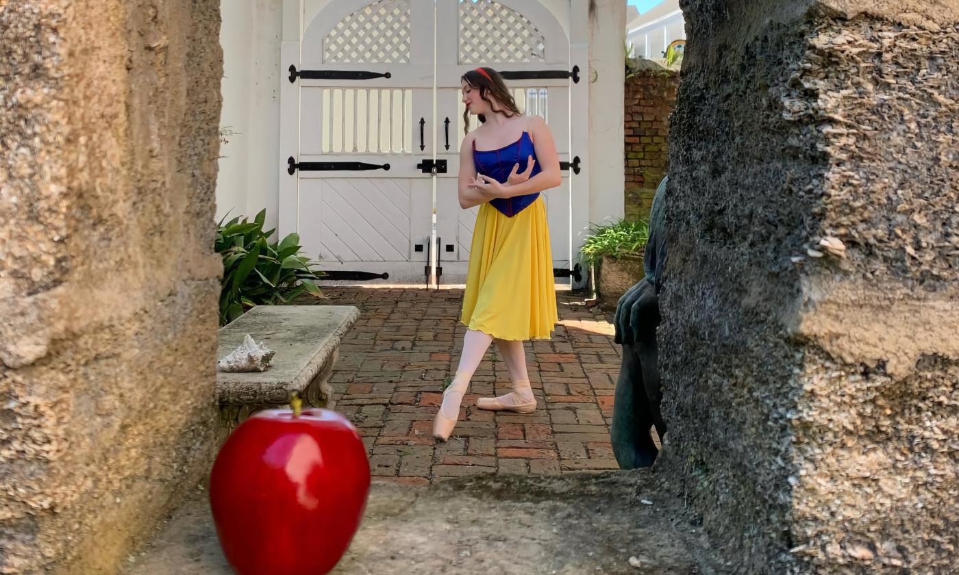 A young ballerina (white girl with dark hair) points her toes in the courtyard of the Oldest House Complex in St. Augustine, Florida