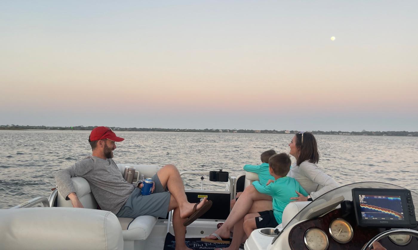 Dad, mom, and two boys enjoying a Tiki Island Adventures private boat charter