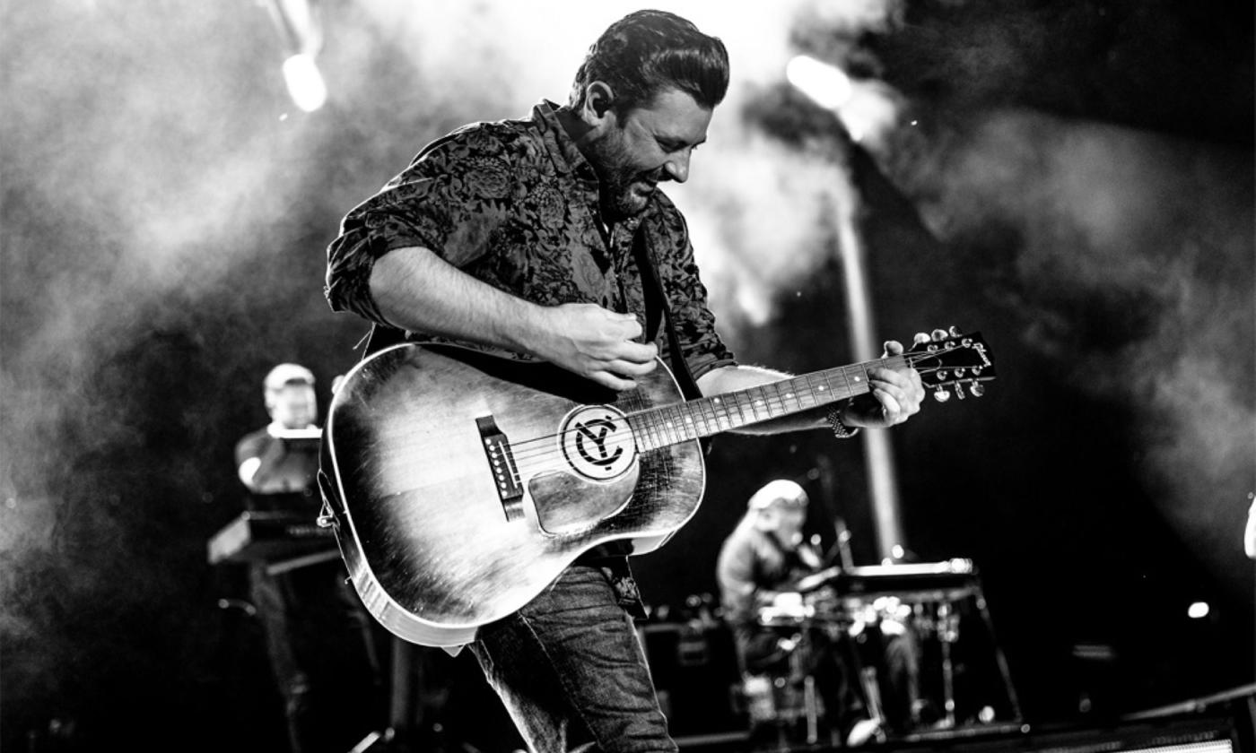 Chris Young strums his guitar on stage