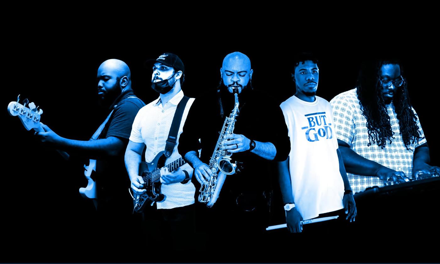 The five members of blue moon, with their instruments, in a studio shot tinted blue