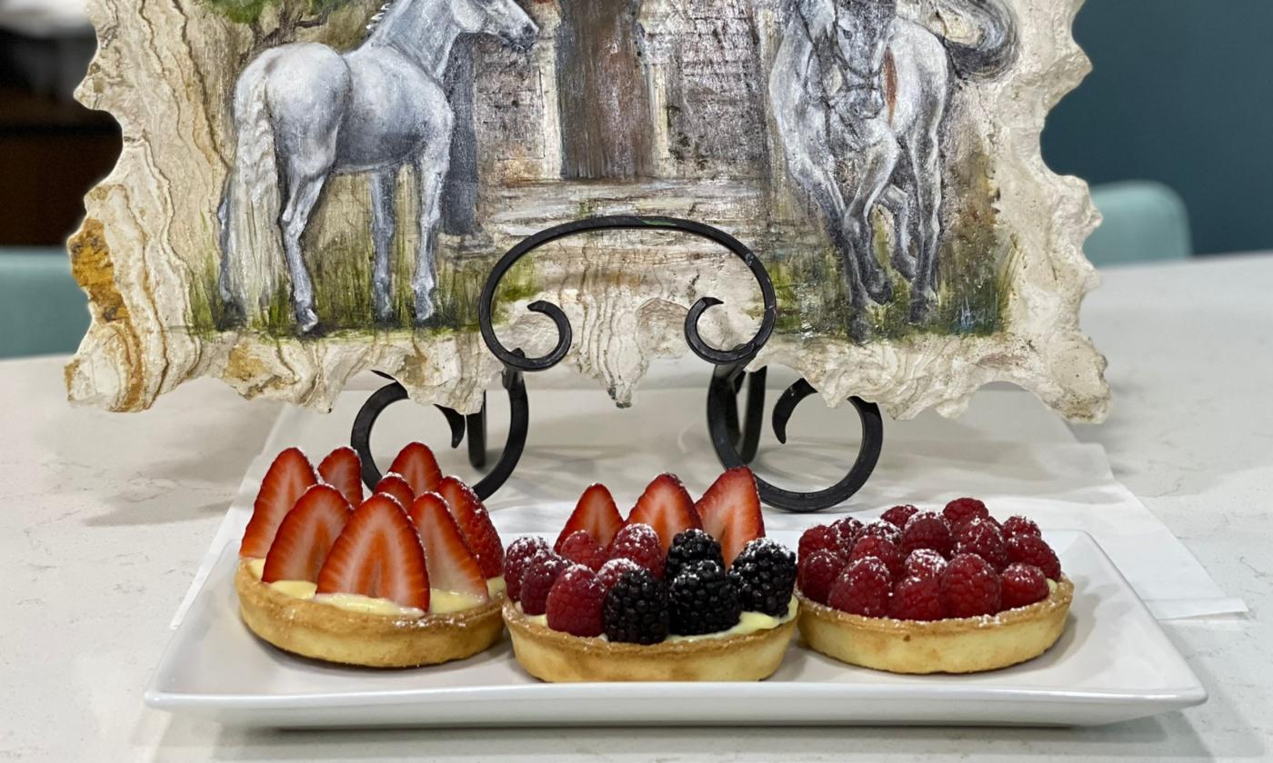 Strawberry tart is positioned in a square dish.