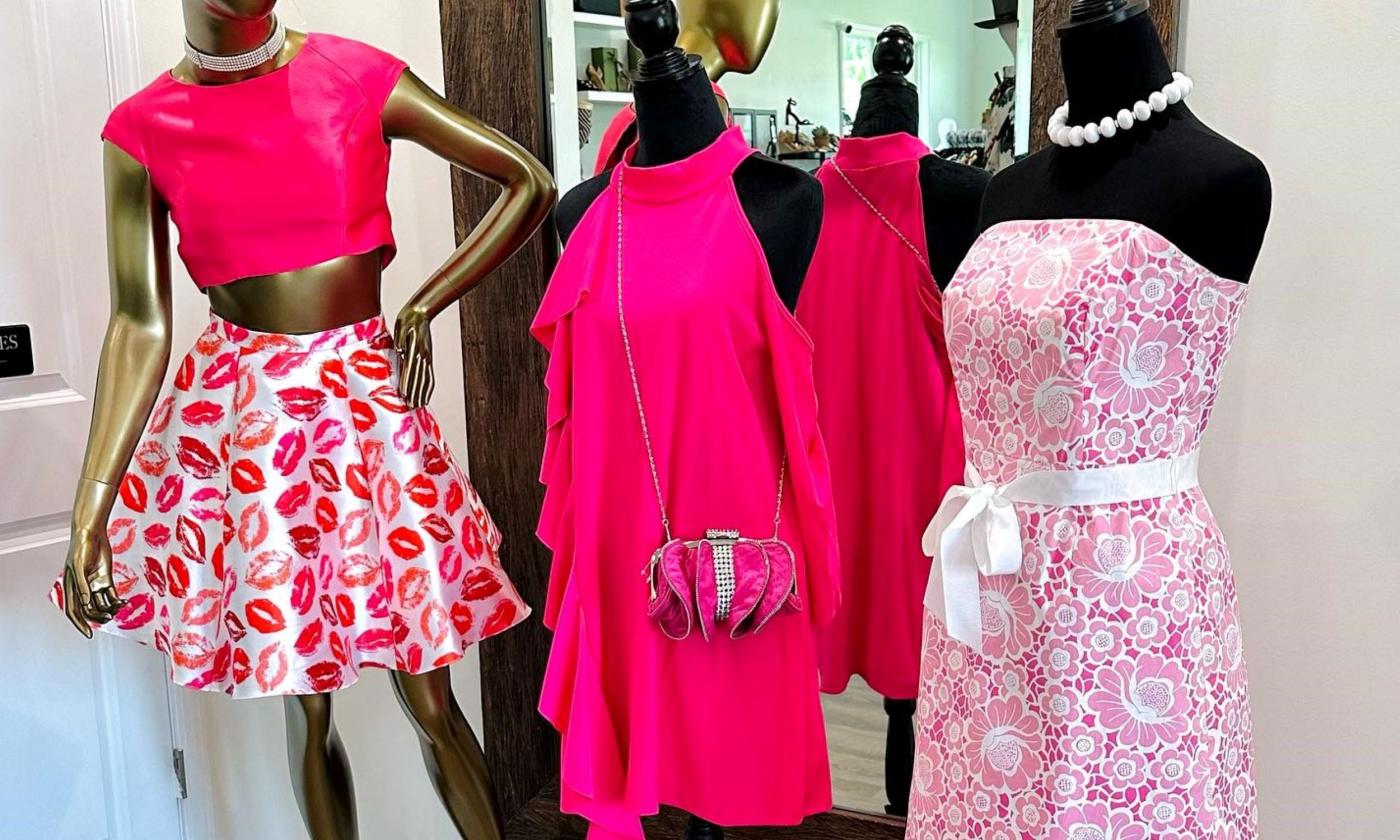 Three pink dresses are placed on display for customers. 