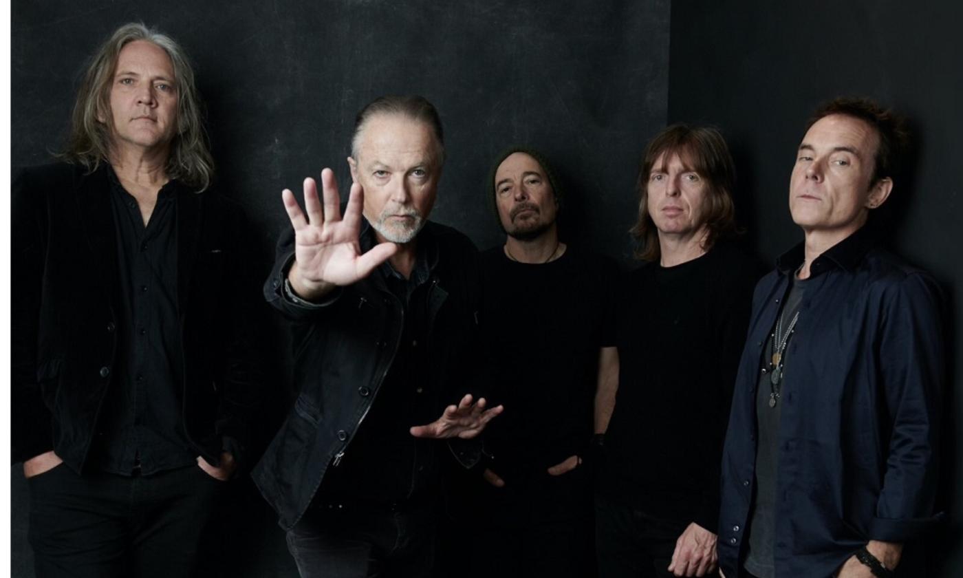 Band members of The Church pose in black clothing.