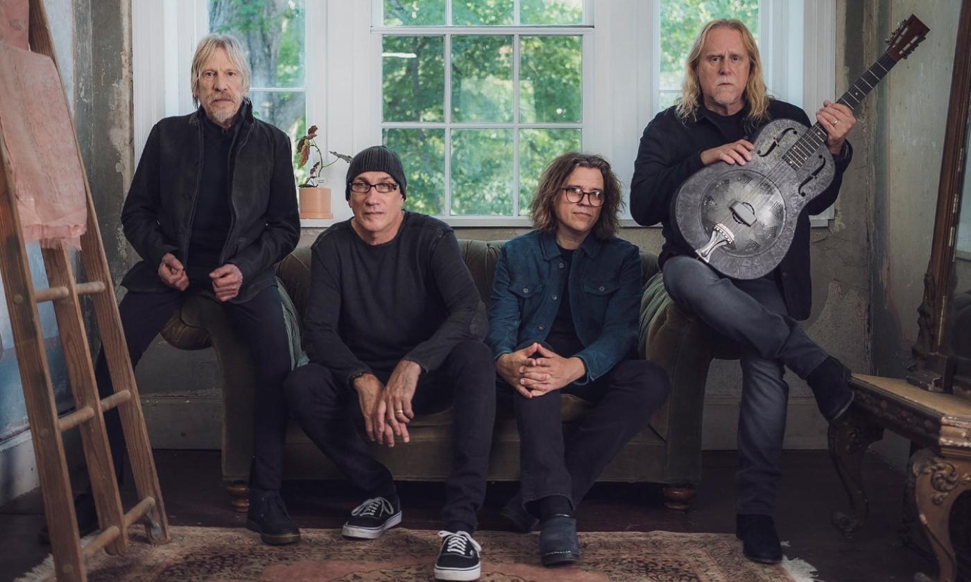 Bandmates from Gov't Mule sit on a couch and pose for the camera.