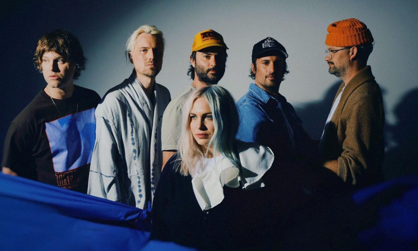 Members of the band The Head and the Heart pose in front of a grey background.