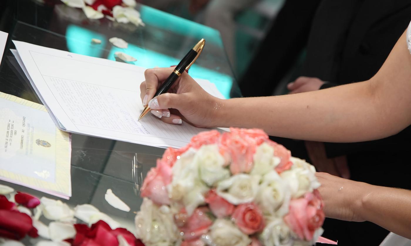 Bride signing marriage legal forms