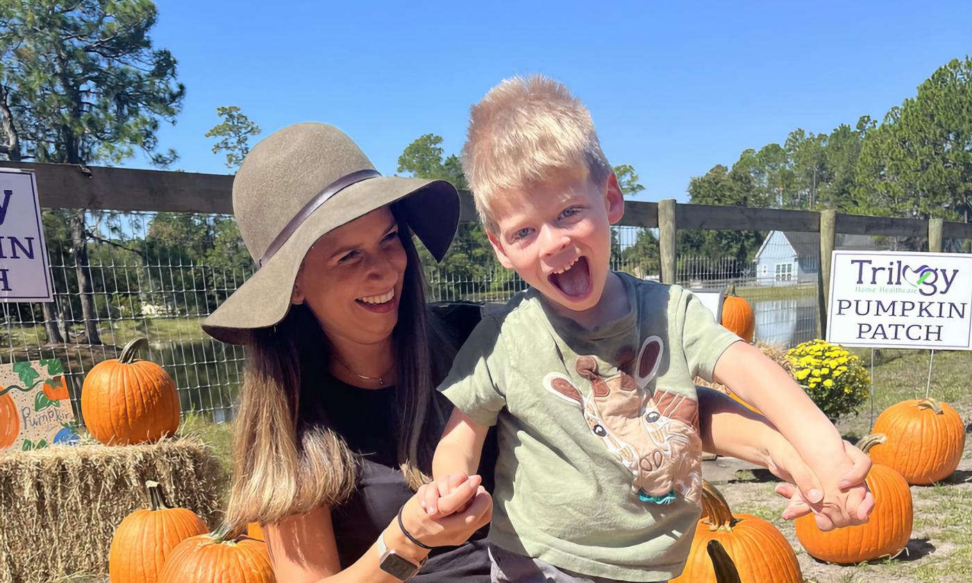 Mom and young son enjoying a pumpkin patch on a sunny day