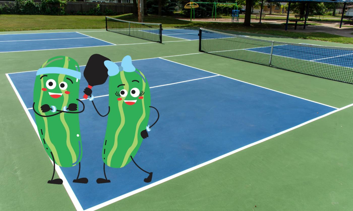Two cartoon dill pickles with paddles on a pickle ball court