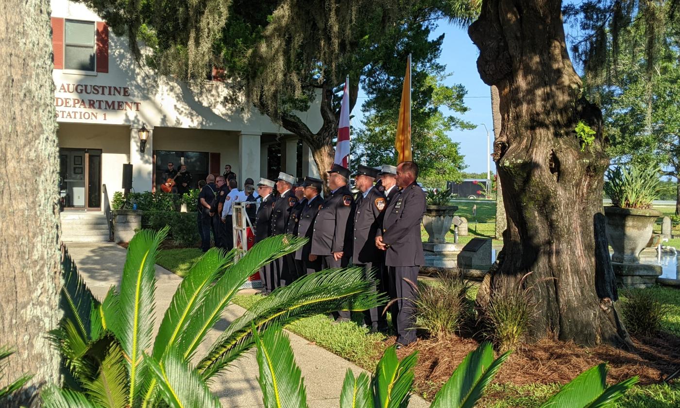 The members of the fire department stand with other dignitaries on the grounds of the Malaga Street Station on 9/11/2023
