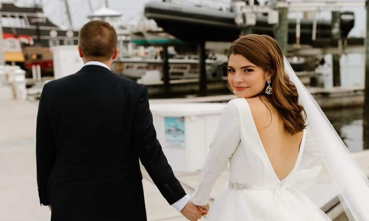 A bride turning to look at camera while walking the dock