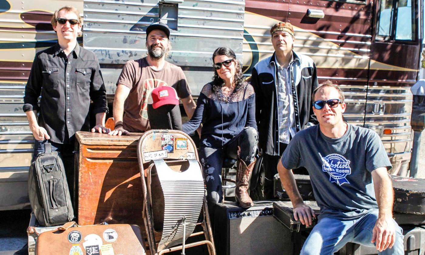 Members of Donna the Buffalo pose in front of a vintage truck. 