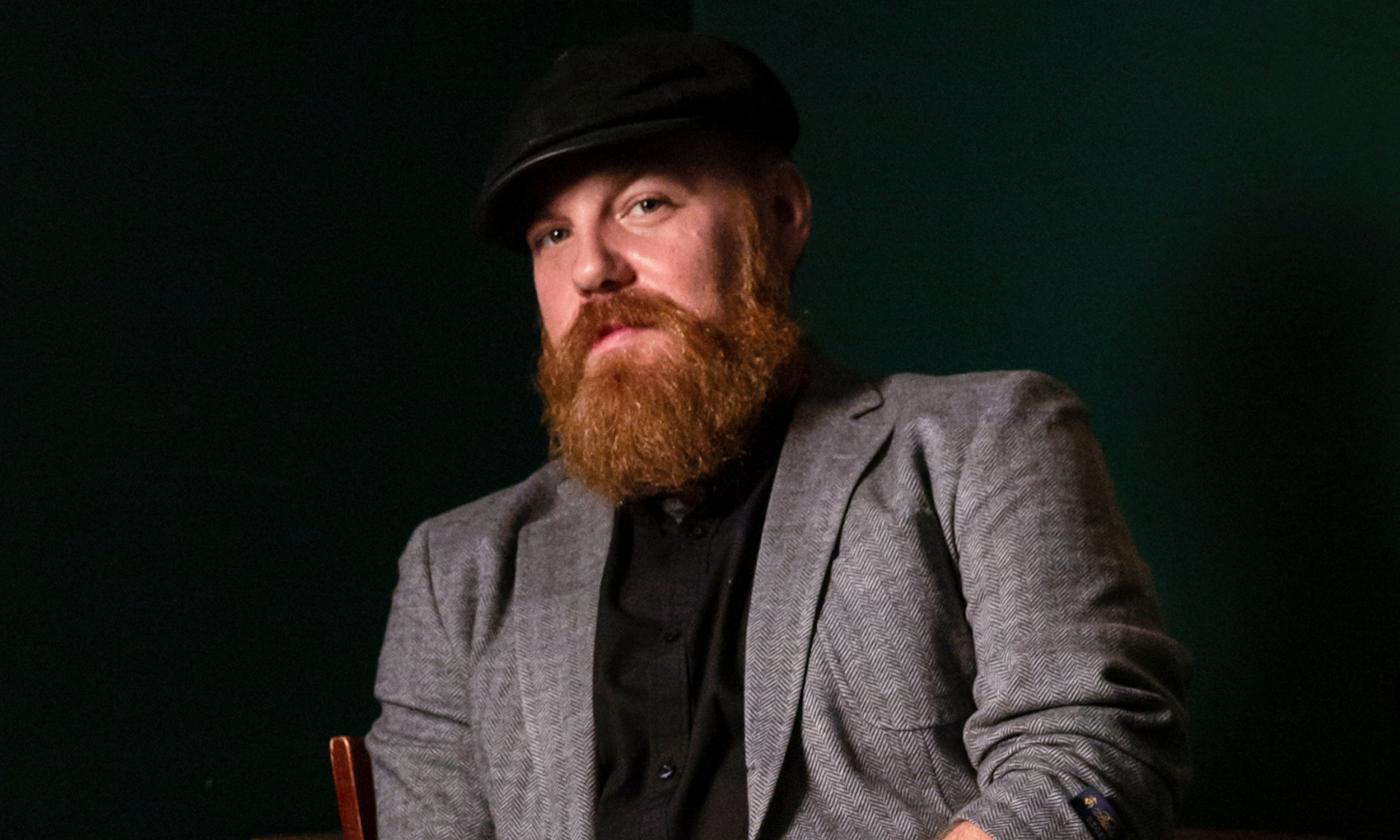 Marc Broussard poses in front of a black background.