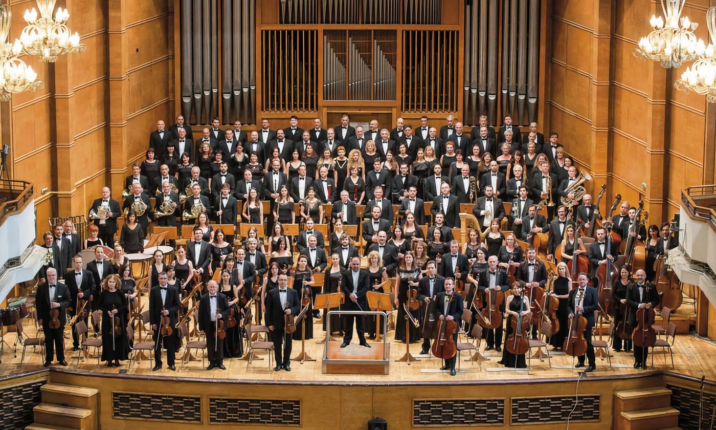 The full Sofia Philharmonic Orchestra standing on stange in Bulgaria