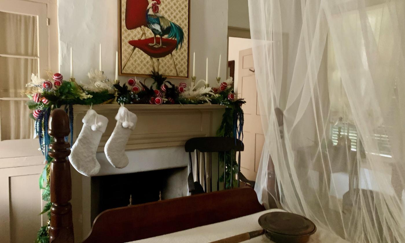 A bedroom with stockings and garland bordering the fireplace