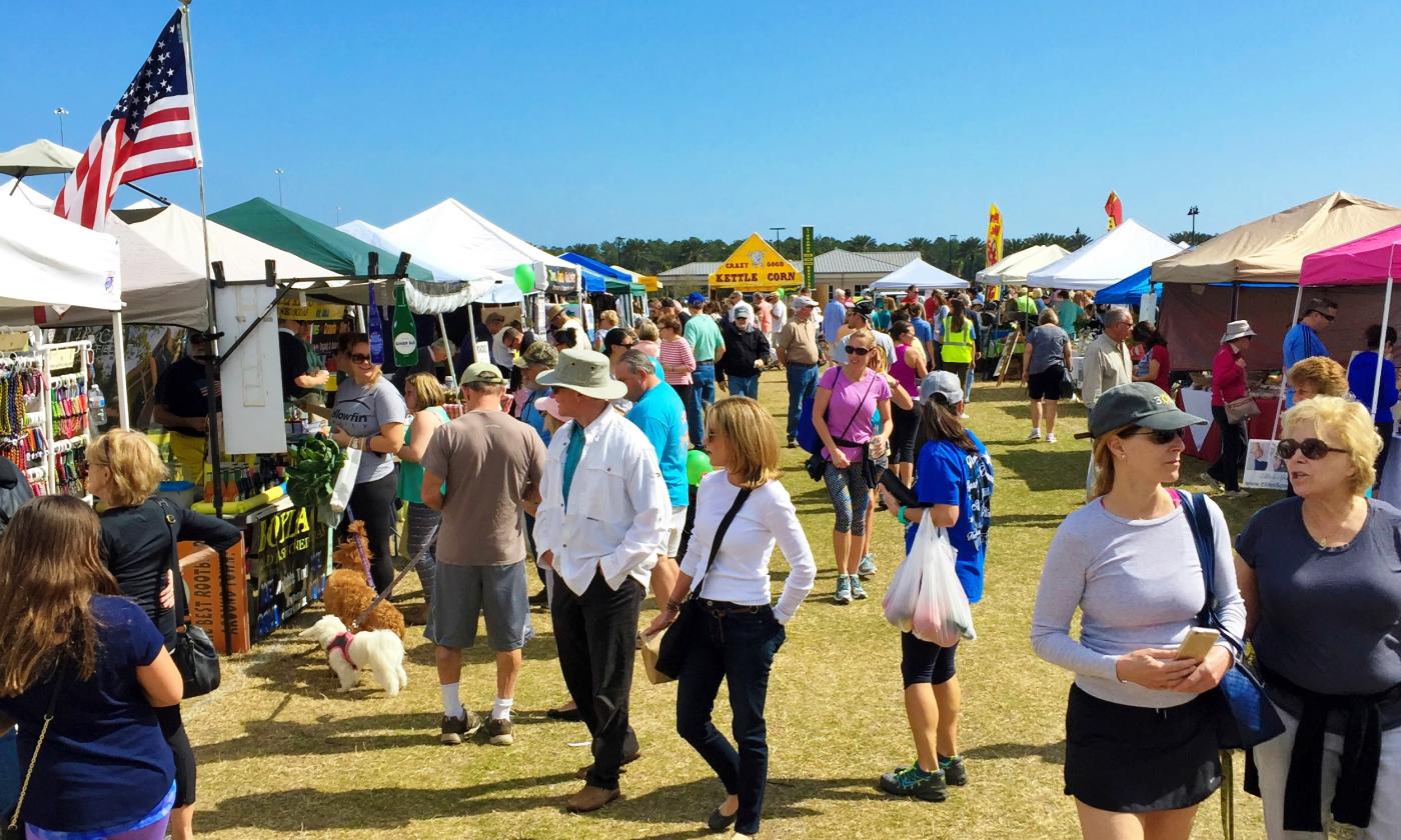 People walking around the vendors tents at the Nocatee Farmers Market