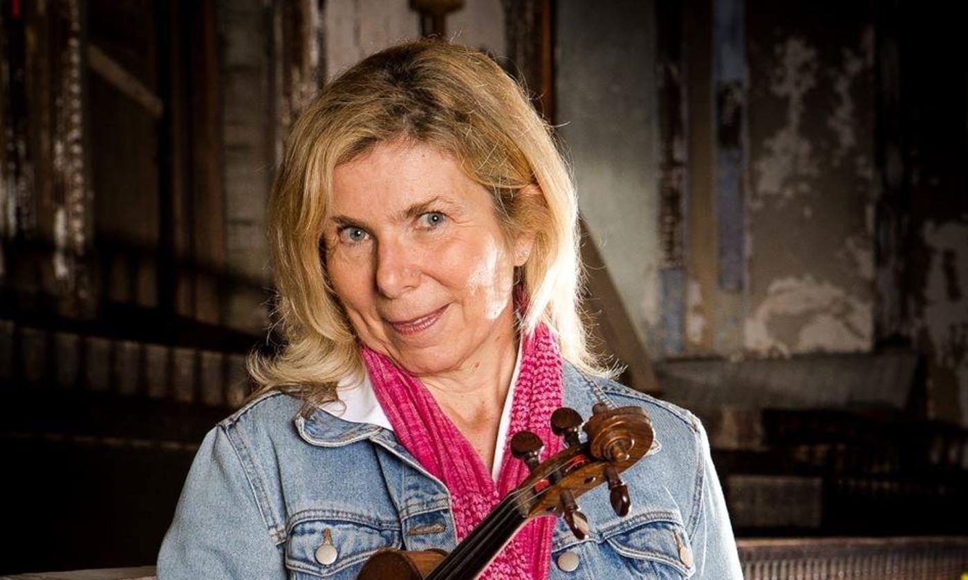 Sue Seymour Westcott smiling, with her fiddle