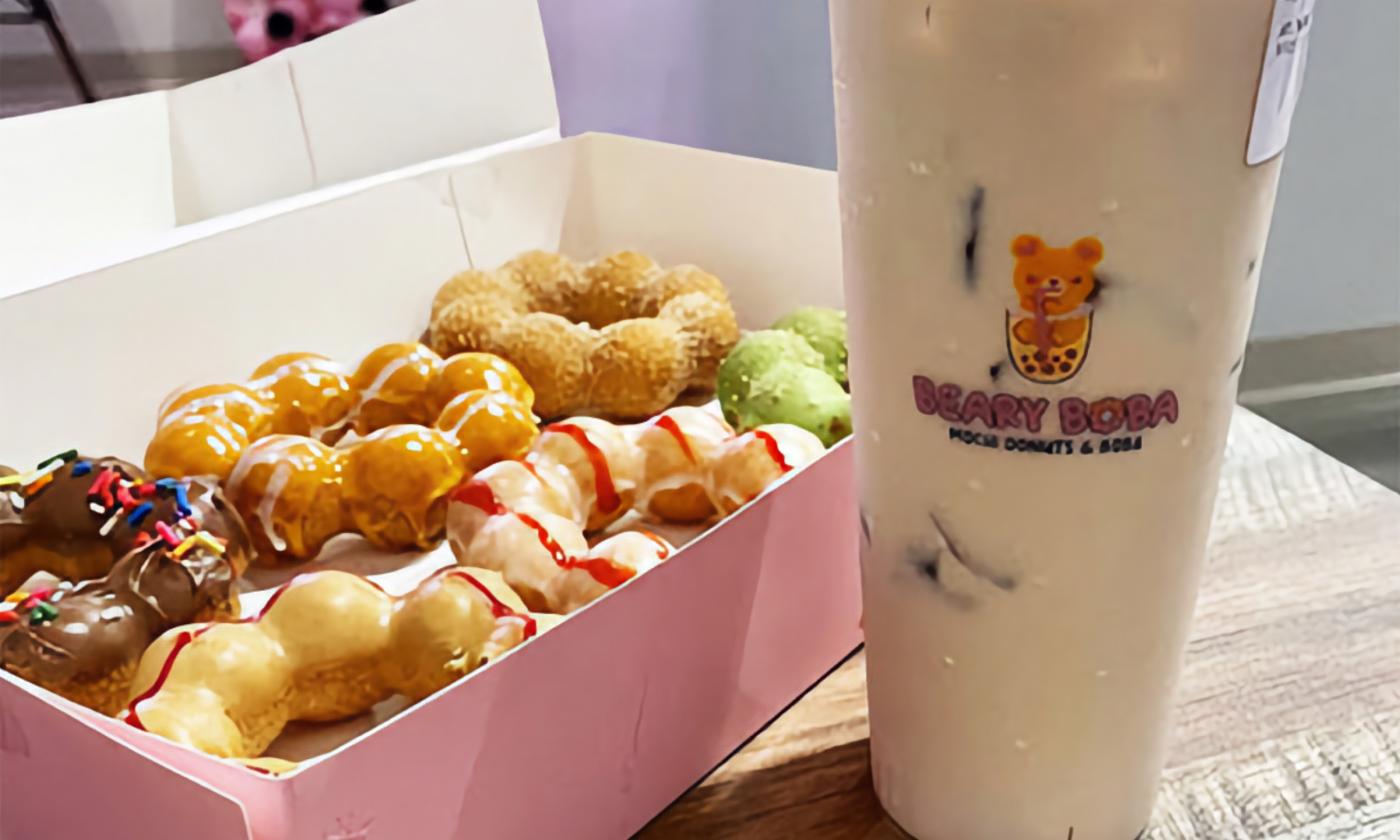 A box of mochi donuts and a milk tea beside it