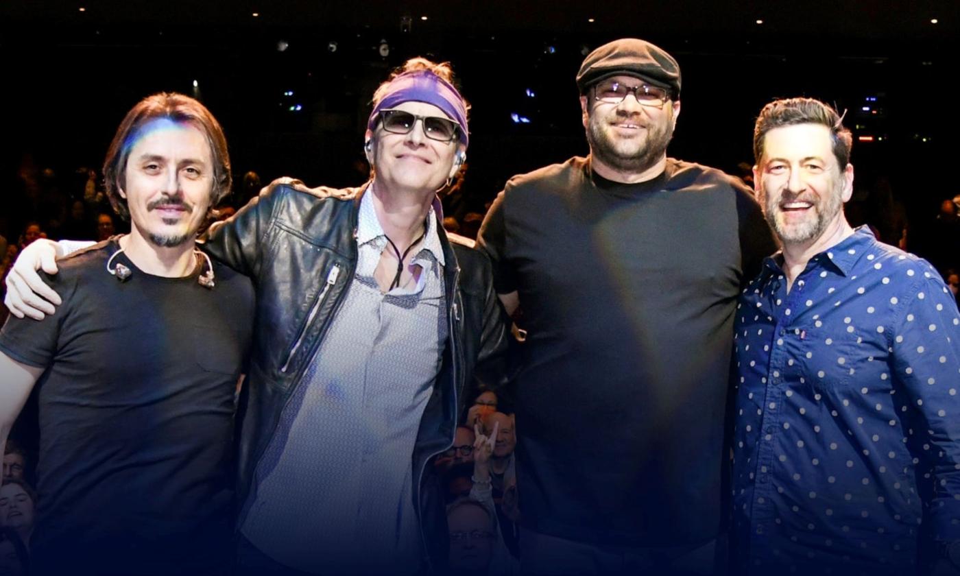 Bandmates from Bodeans pose in front of a black backdrop.