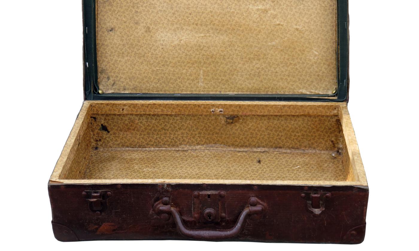 An old, brown suitcase, open and empty