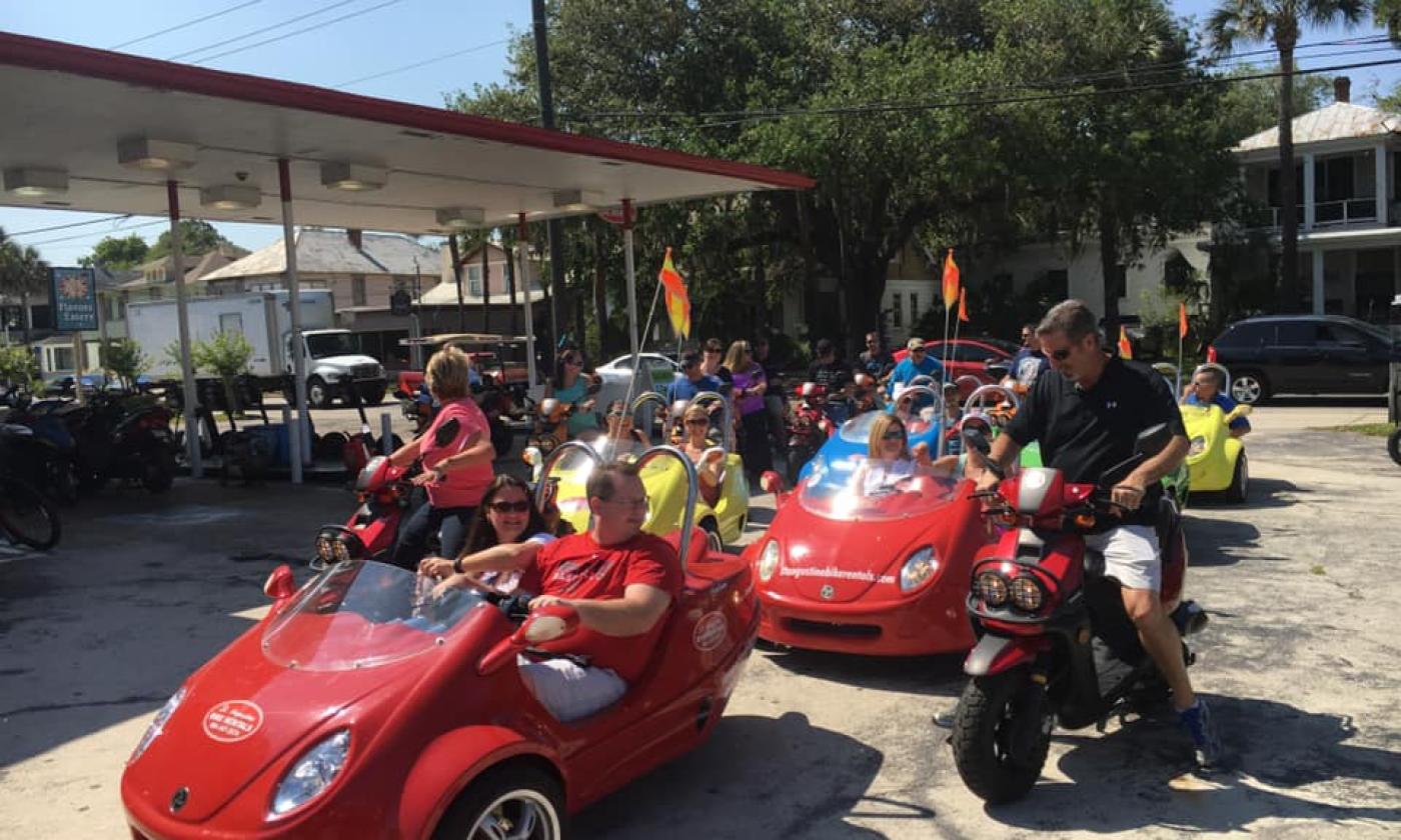 A large group of friends, getting ready to tour the city on scooters and scoot coupes