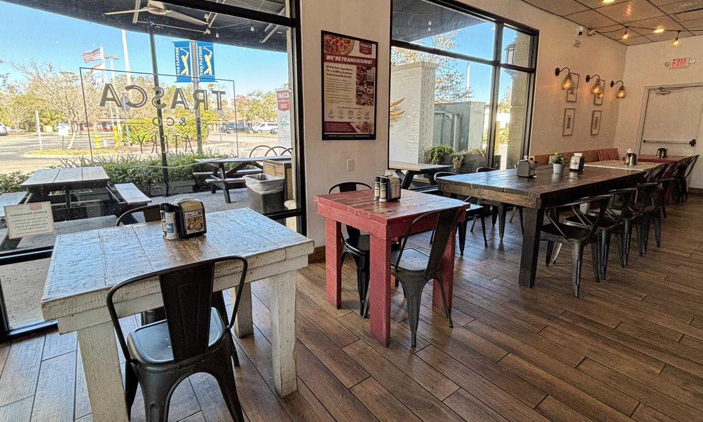 The indoor dining section with tables and chairs lining the windows