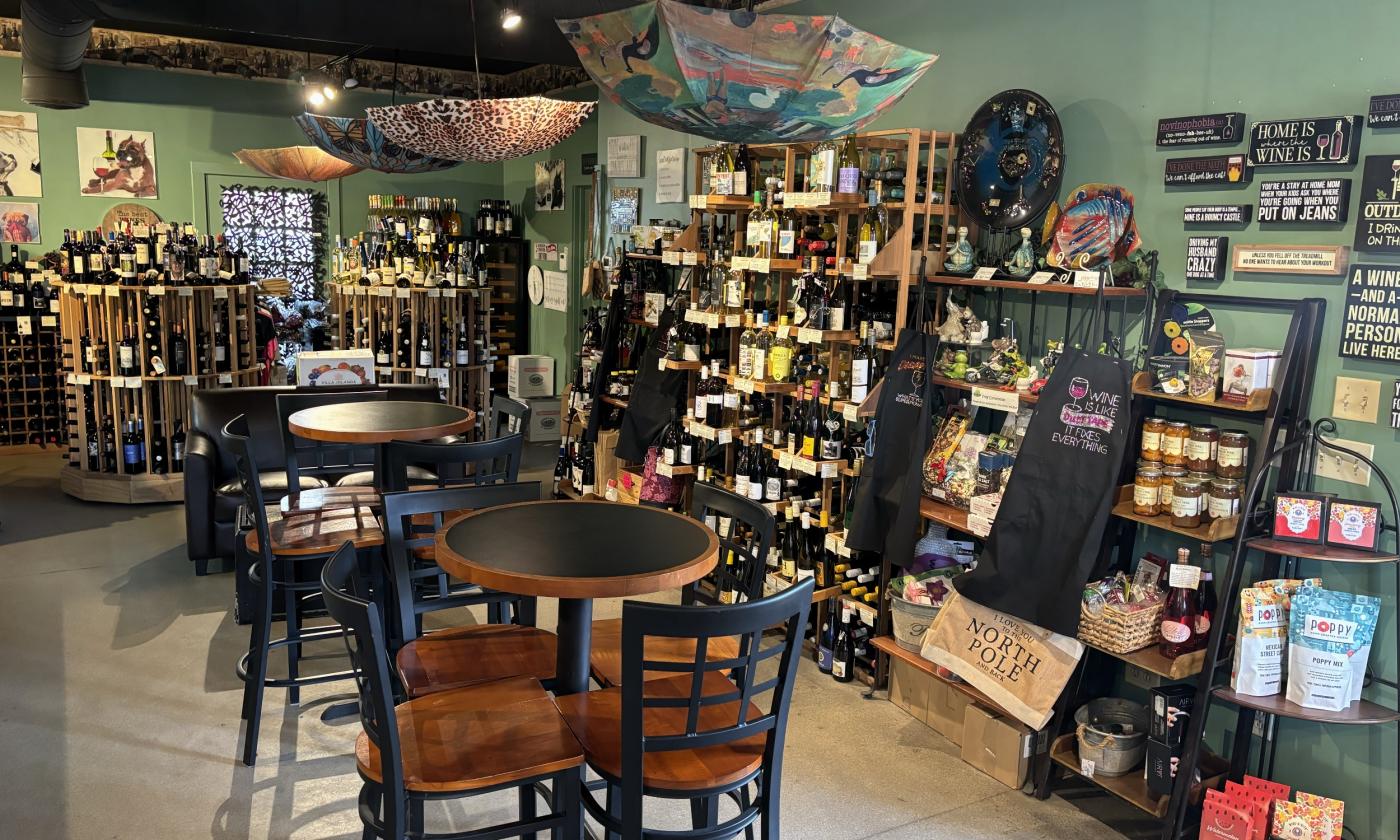 The wine collection lining the wall with umbrella decor hanging